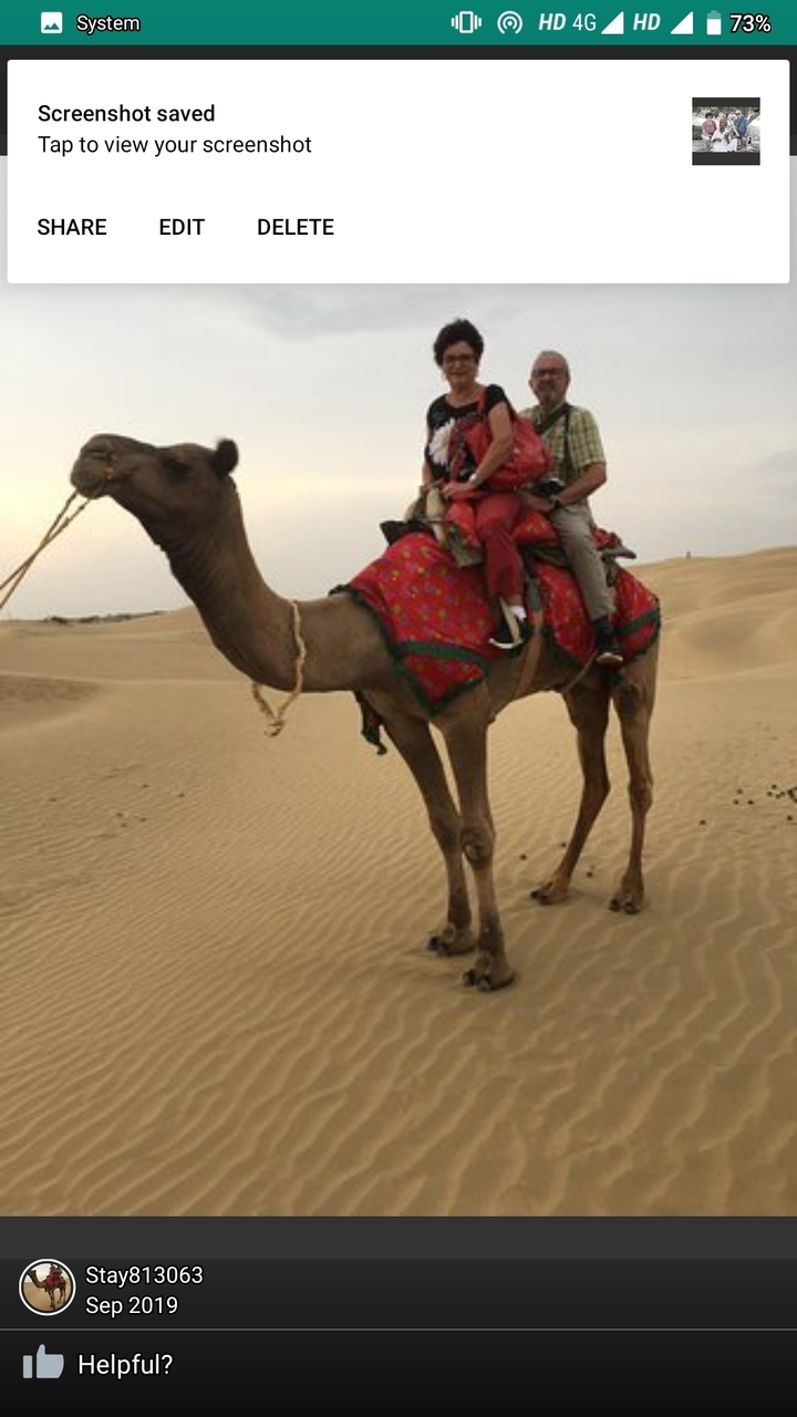 Couple chevauchant un chameau dans le désert.