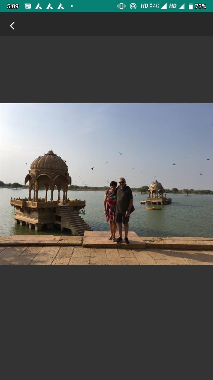 Couple debout devant un pavillon sur un lac.