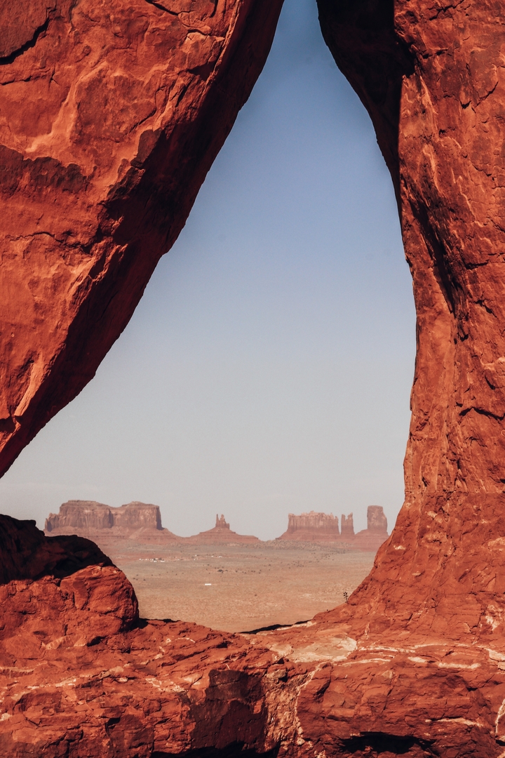 View through a rock arch out to distant formations.