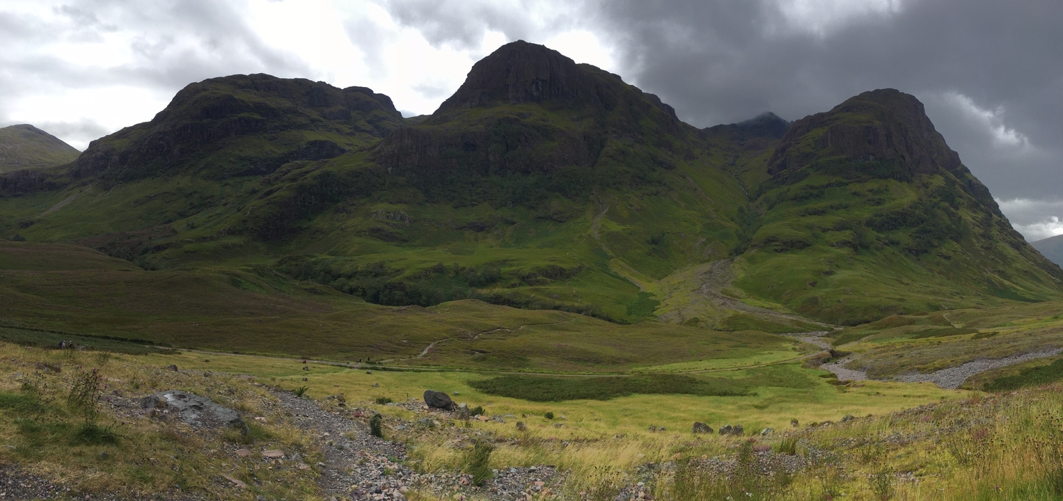 Un paysage montagneux dramatique avec des champs herbeux.