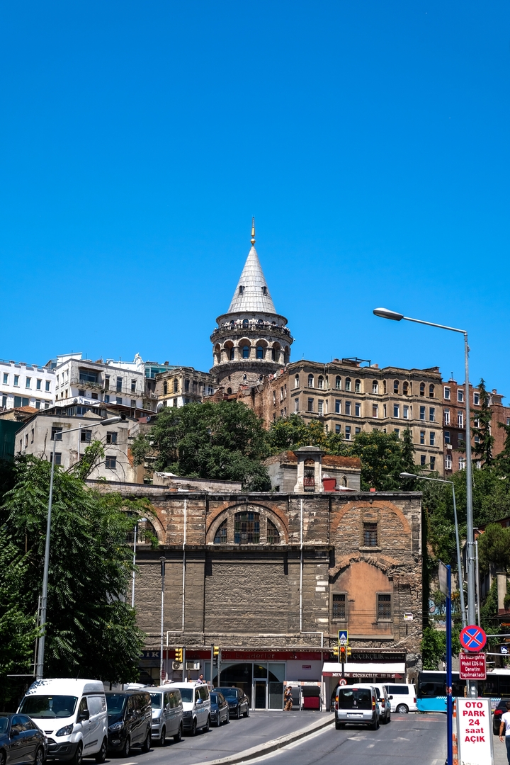 A close-up of the Galata Tower surrounded by buildings.