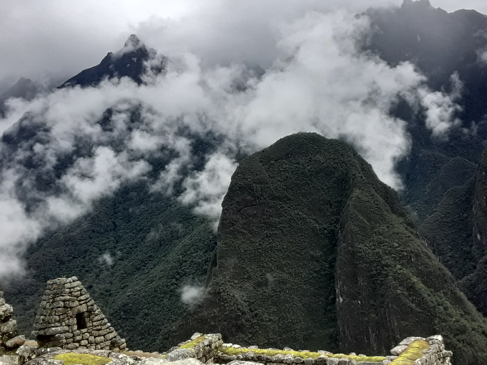 Clouds swirl around steep green Andean peaks near Machu Picchu