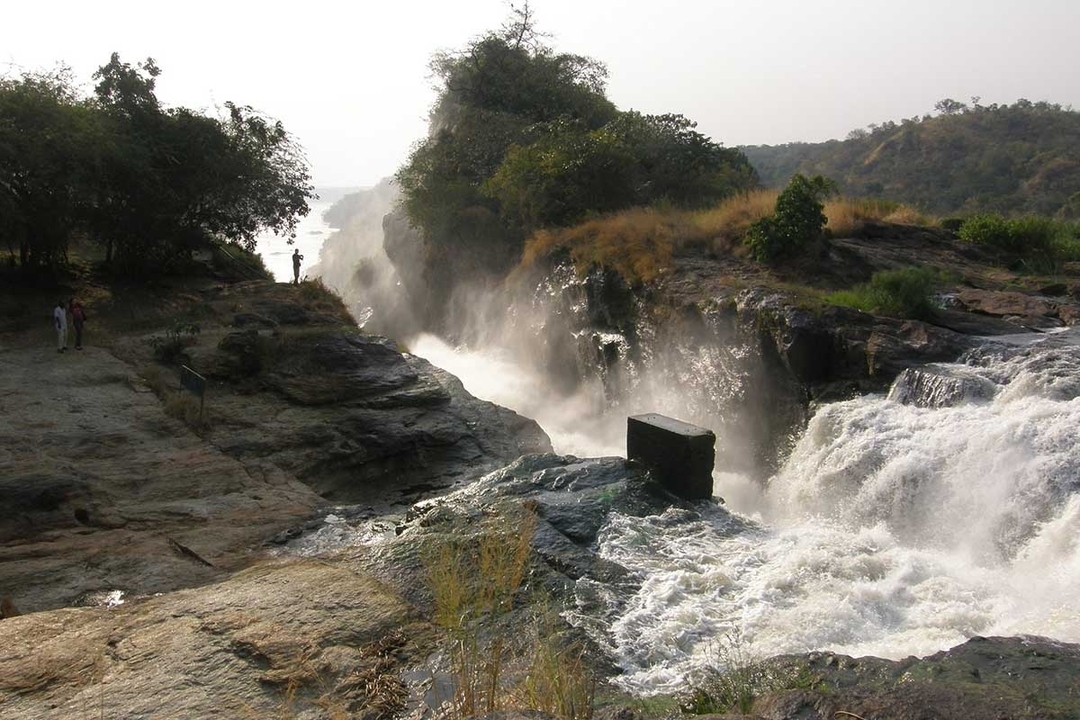 Des visiteurs observant une chute d'eau avec de la brume qui s'élève.