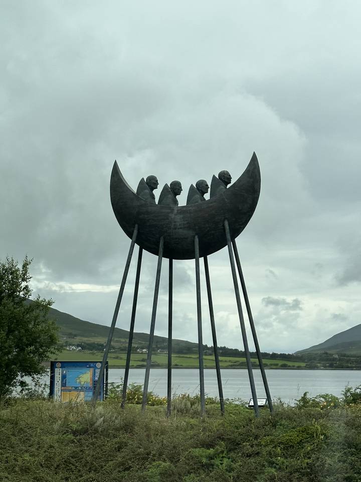 Un monument d'art moderne représentant des figures avec une vue sur le paysage.