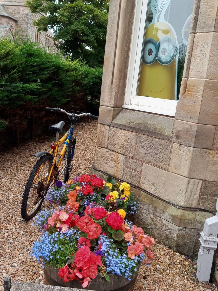 Vélo et fleurs devant un bâtiment rustique plein de caractère.