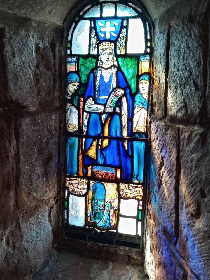 Vitrail coloré dans un cadre de pierre.