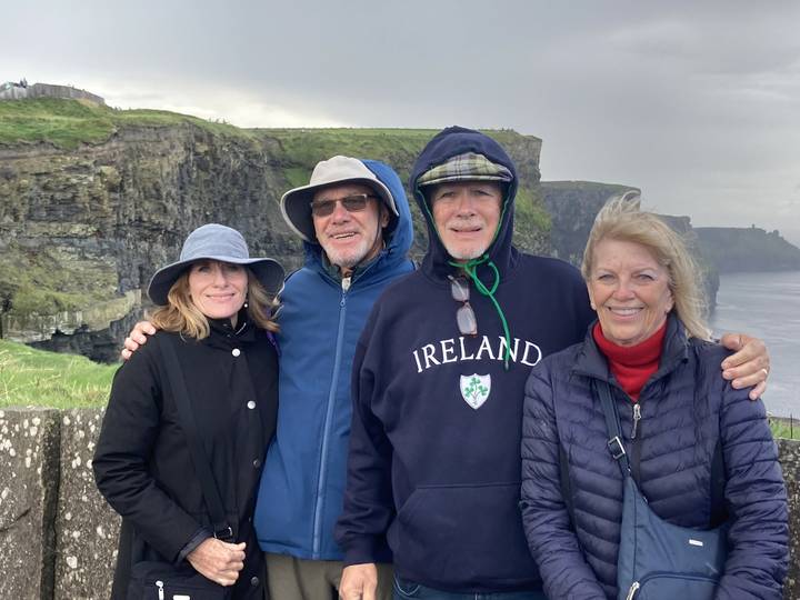 Groupe de personnes posant avec une falaise pittoresque en arrière-plan.