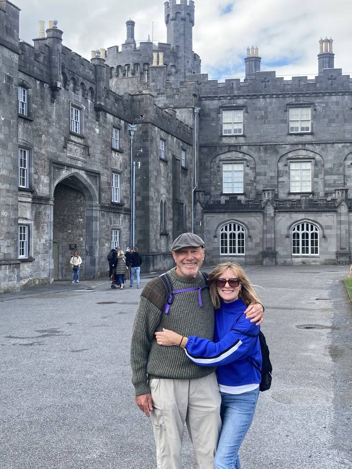 Couple posant devant un bâtiment historique.