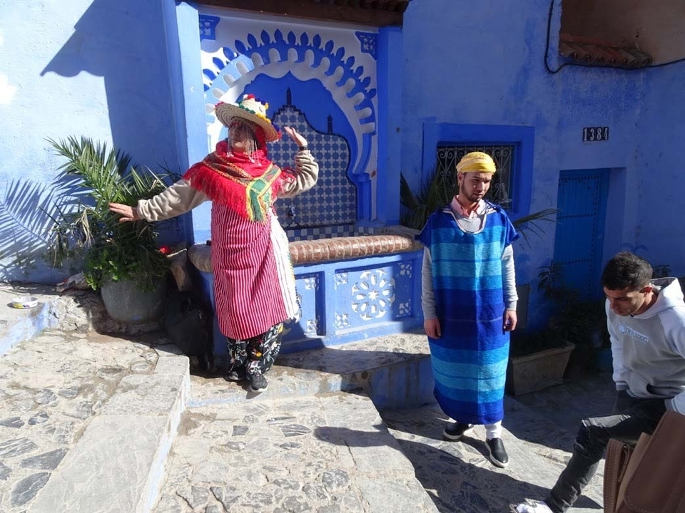 Personnes en tenue traditionnelle dans un espace aux tons bleus
