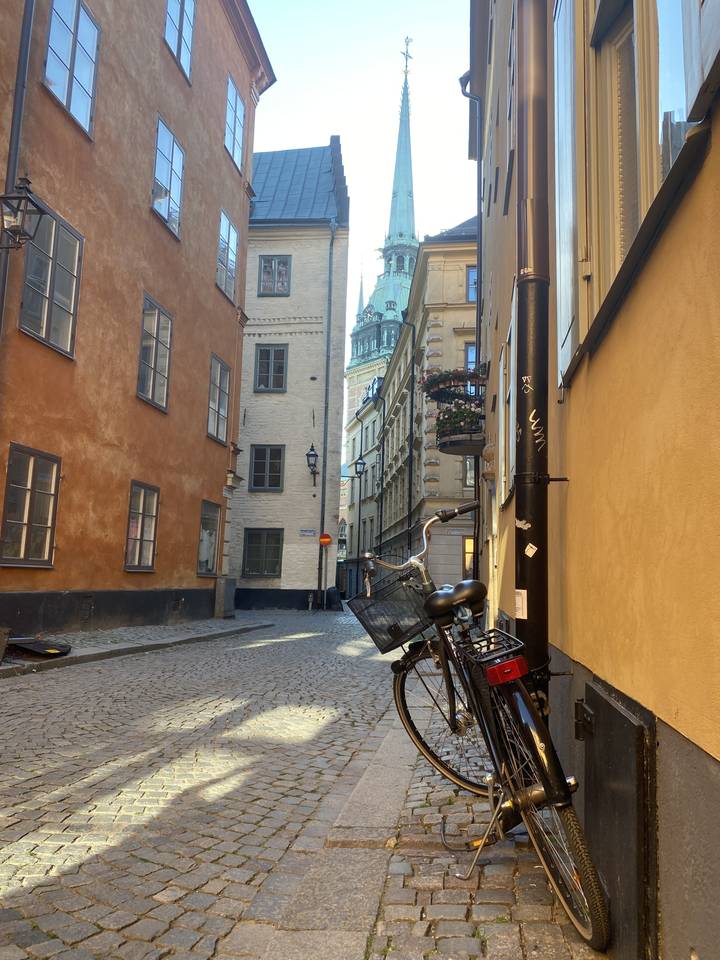 Vélo garé dans une rue pavée étroite.
