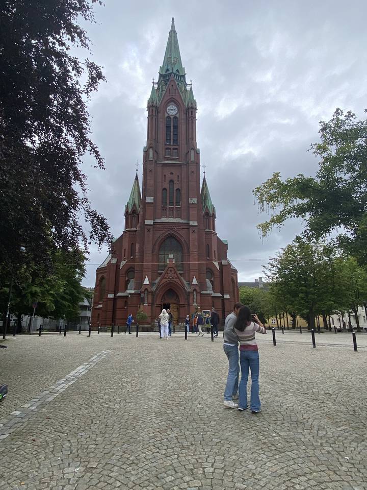 Des gens debout devant un bâtiment d'église.
