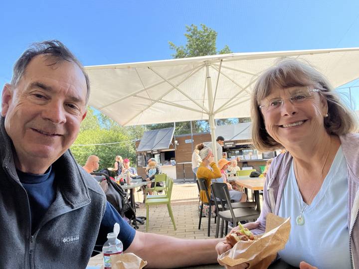 Deux personnes dans un café décontracté avec des sièges en terrasse.