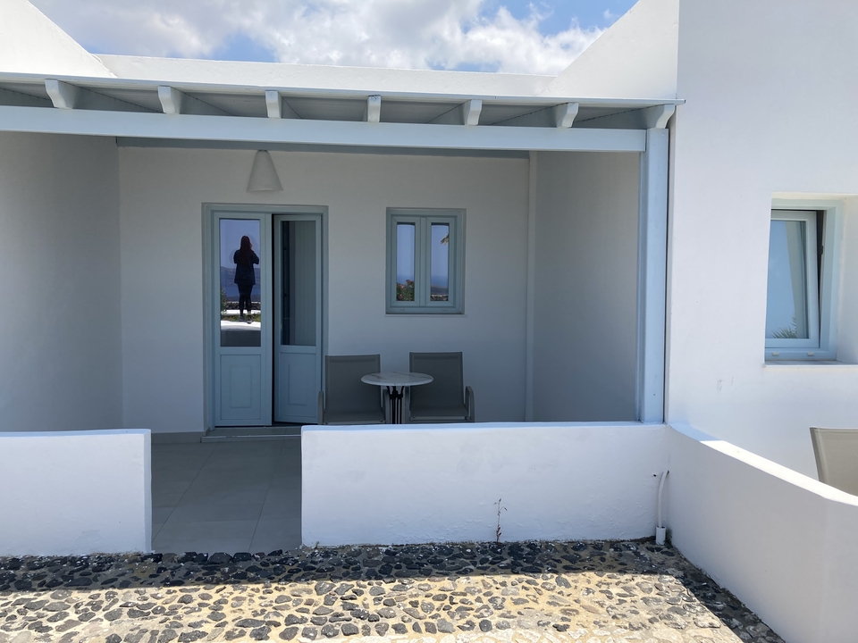 Terrasse blanche avec des portes et fenêtres bleues.