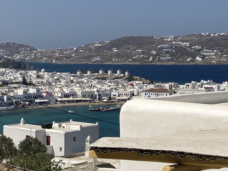 Vue de Mykonos avec moulins à vent et mer bleue.