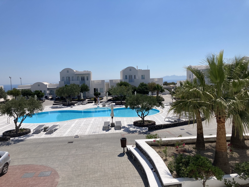 Zone de villégiature avec piscine et palmiers.