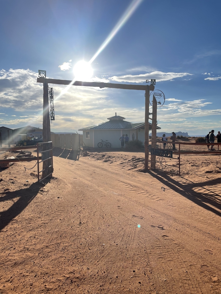 Entrée d'un ranch dans le désert avec des gens et des vélos.