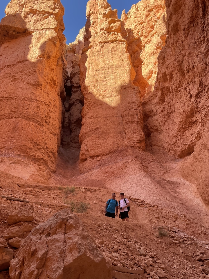 Imposantes formations rocheuses rouges avec des personnes à la base.