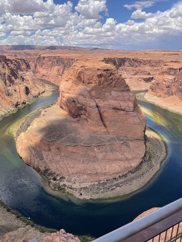 Méandre en fer à cheval d'une rivière avec des parois de canyon escarpées.