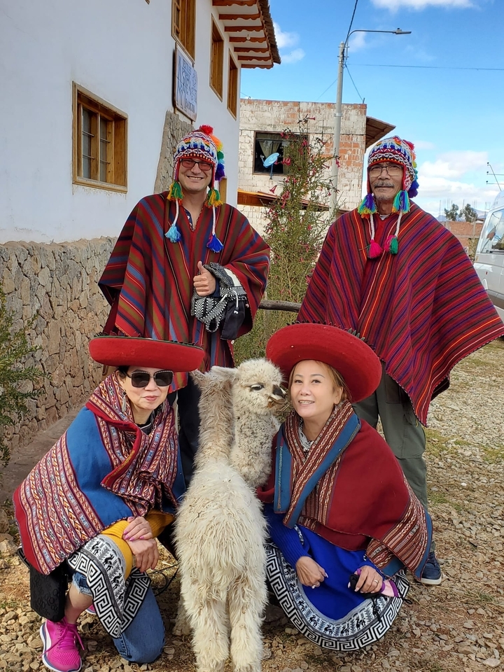 Groupe portant des vêtements traditionnels avec un lama.