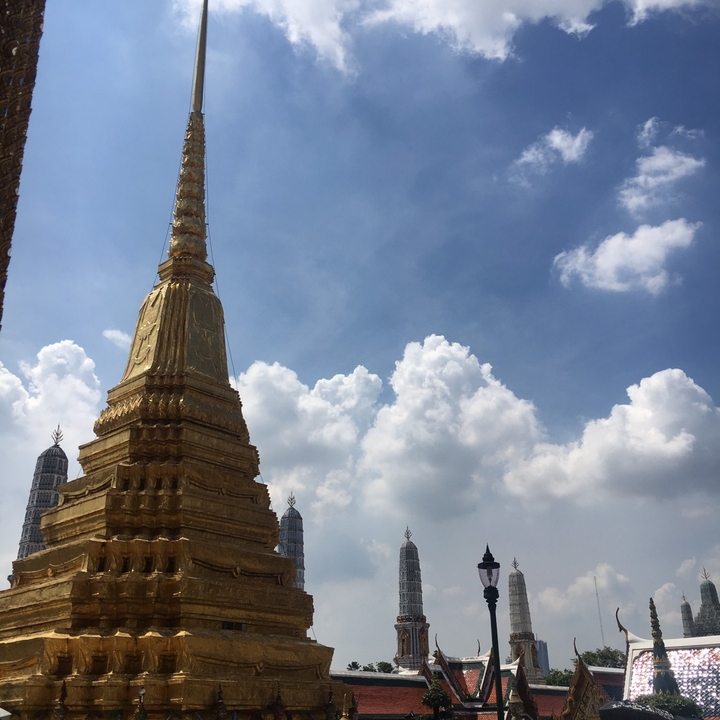 Stupa doré contre un ciel bleu avec des nuages.