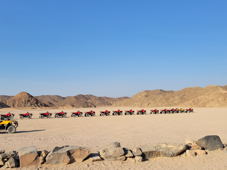 Ligne de VTT dans un paysage désertique avec des collines rocheuses.