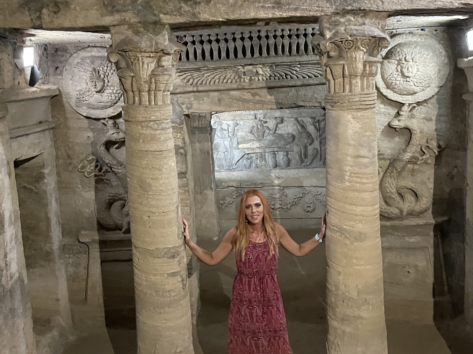 Personne debout entre d'anciens piliers de pierre dans un tombeau.