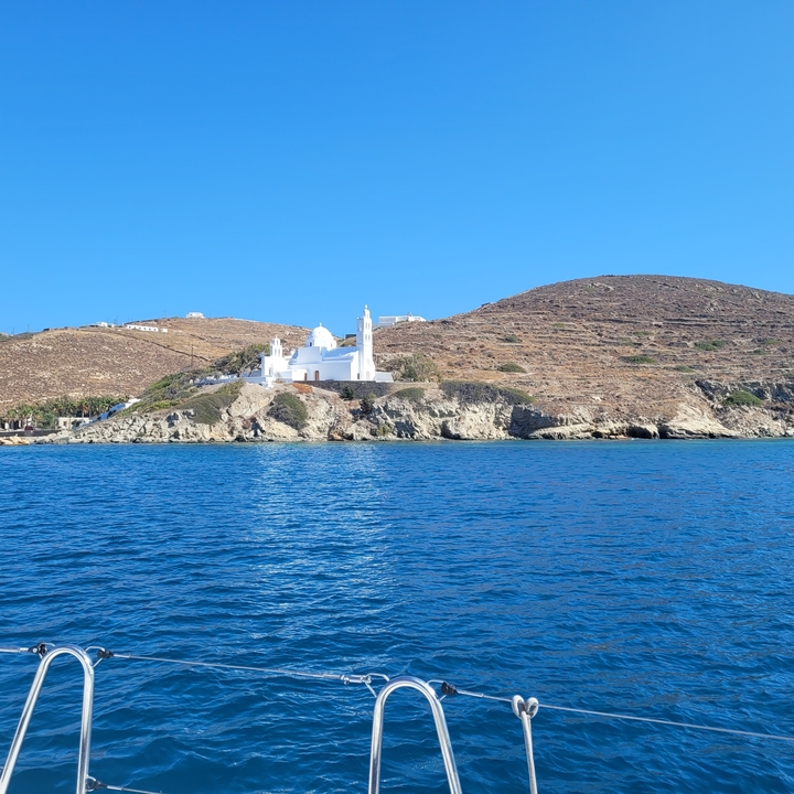 Église blanche sur un promontoire surplombant la mer.