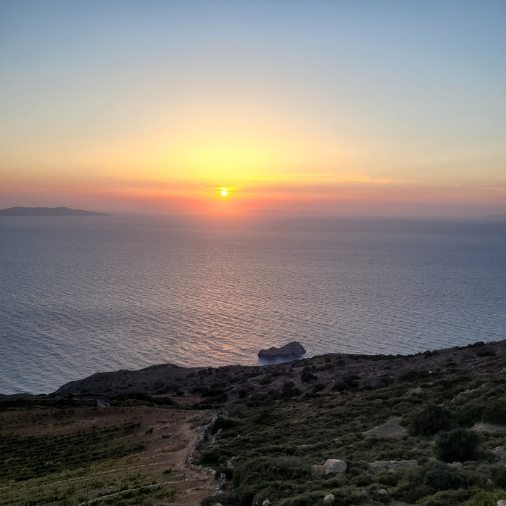Coucher de soleil sur l'océan avec des îles lointaines.
