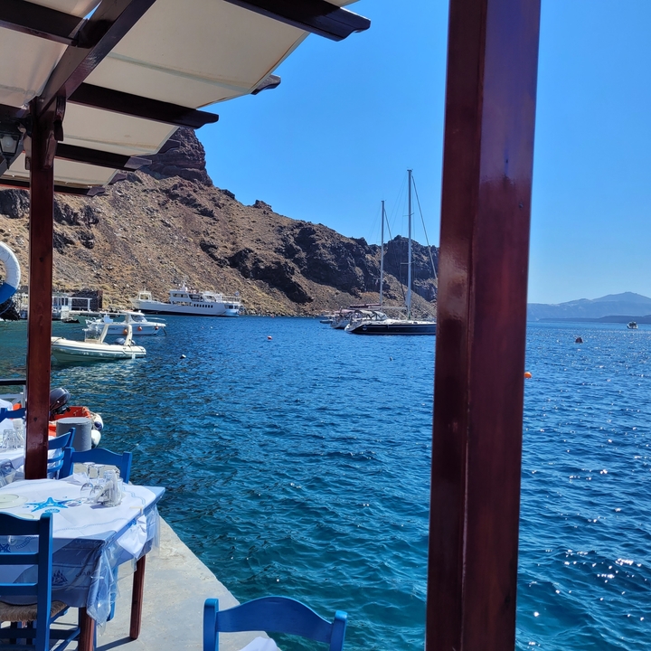 Vue du port avec des bateaux amarrés près d'un paysage rocheux.