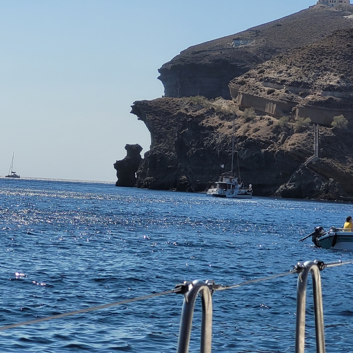 Bateau naviguant le long d'une côte rocheuse.