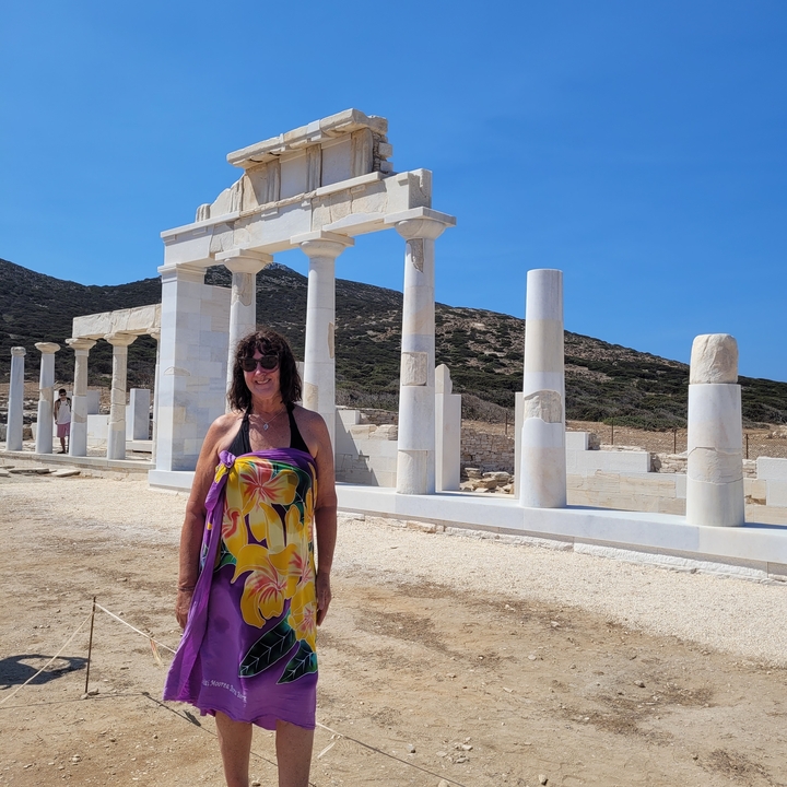 Femme posant devant des ruines antiques.