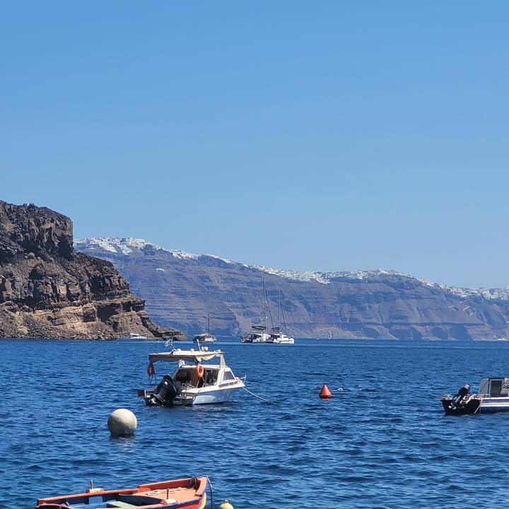 Bateaux flottant dans la mer avec des collines en arrière-plan.