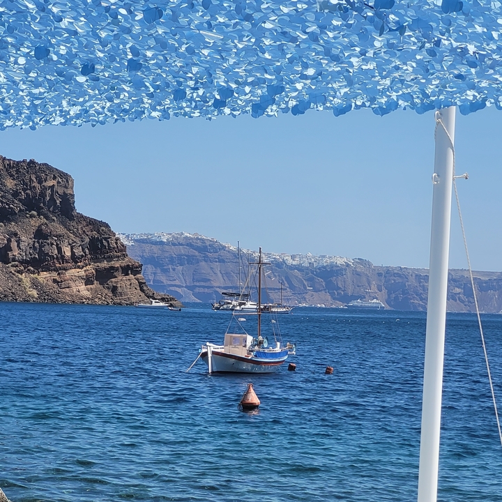 Petit bateau sur la mer avec des montagnes en arrière-plan.
