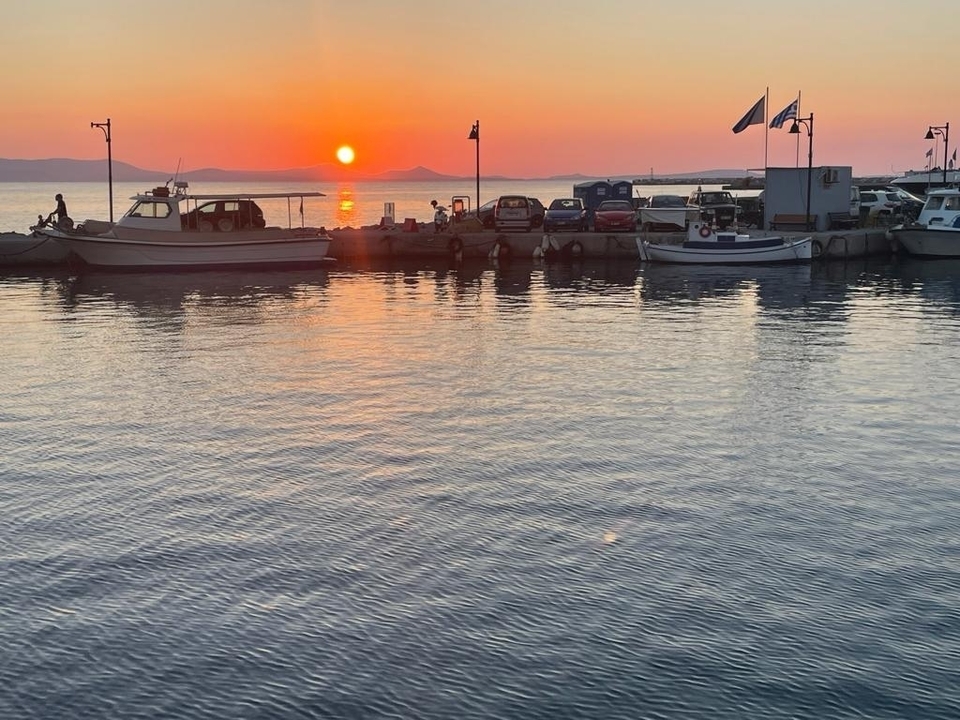 Coucher de soleil sur une marina avec des bateaux à quai.