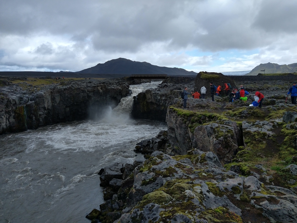 Des gens explorant une chute d'eau en Islande.