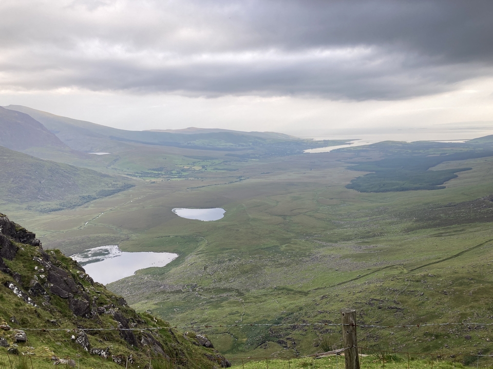 Expansive view of a valley with lakes and hills.