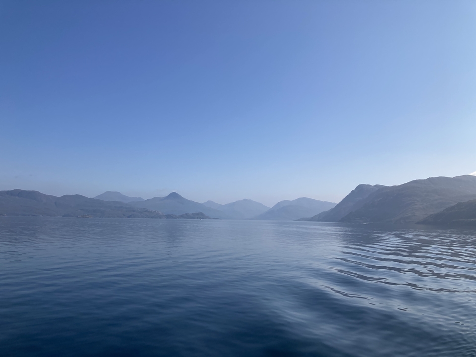 Vue large d'un lac avec des montagnes en arrière-plan.