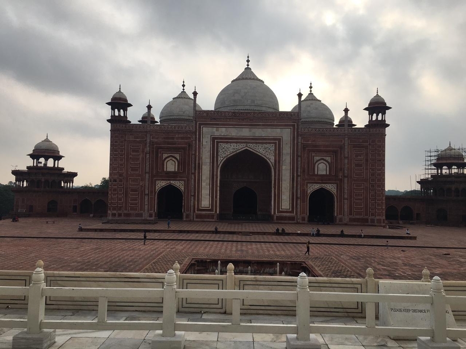 Extérieur d'une mosquée en grès rouge dans une cour.