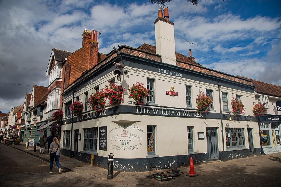 Pub historique avec des décorations florales sur la façade.