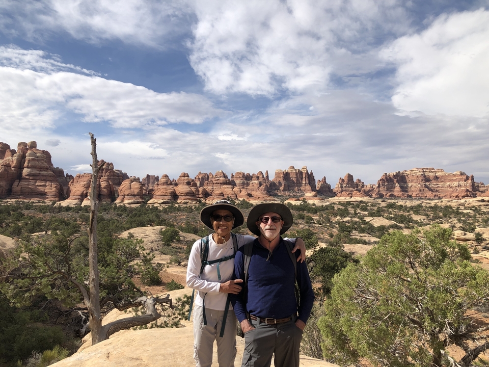 Deux personnes posant devant des formations rocheuses sous un ciel nuageux.