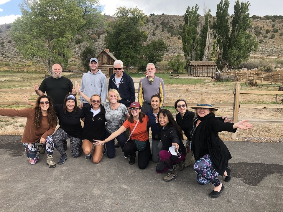 Groupe de personnes posant avec un arrière-plan rustique.