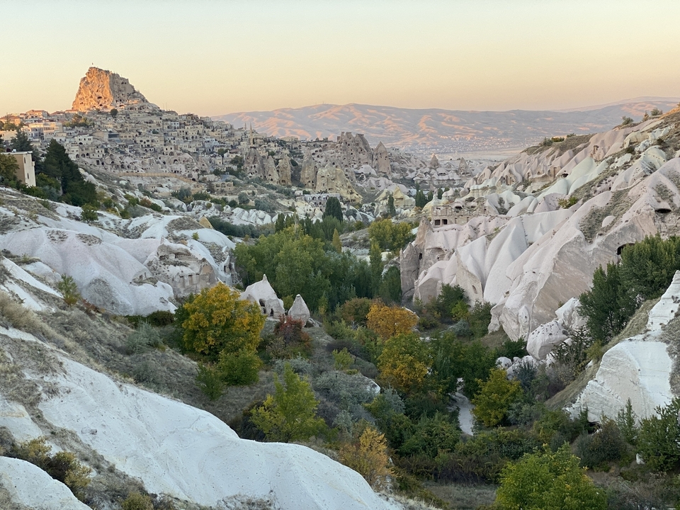 Vue panoramique d'une vallée avec des formations rocheuses et une ville.