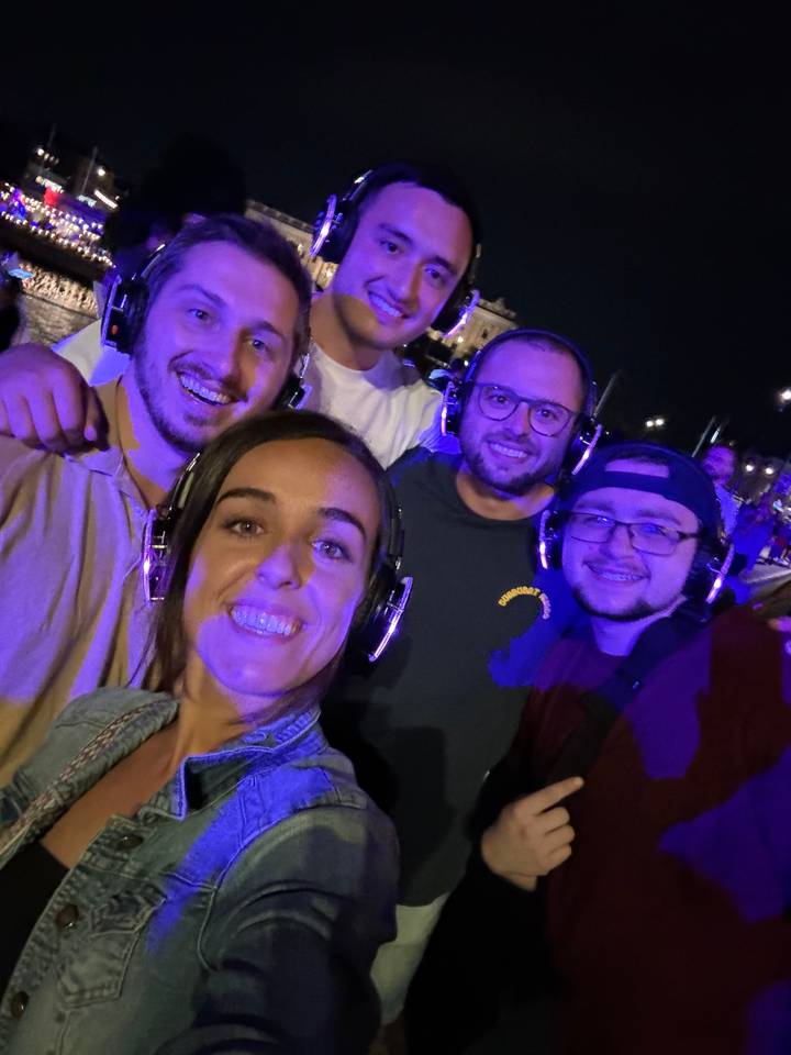 Group of people wearing headphones at a nighttime event.