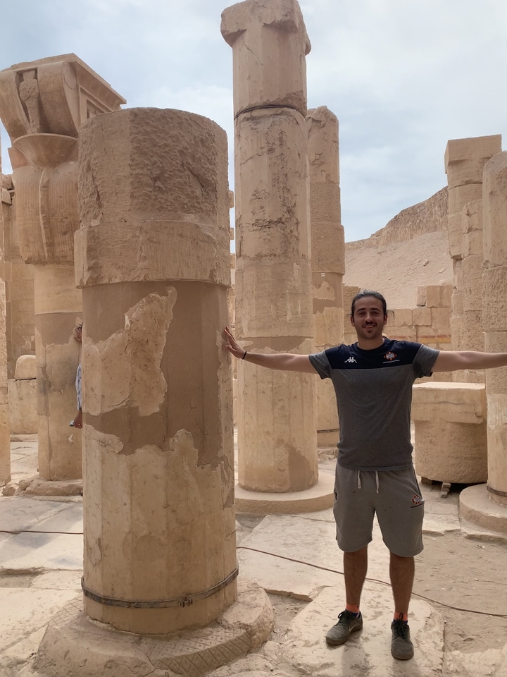 Personne qui pose à l'intérieur d'une ruine de temple