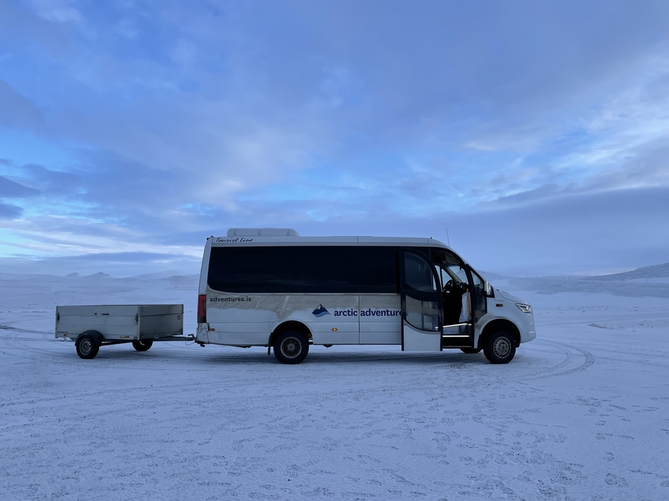 Autobus de tournée Arctic Adventures sur un paysage enneigé.