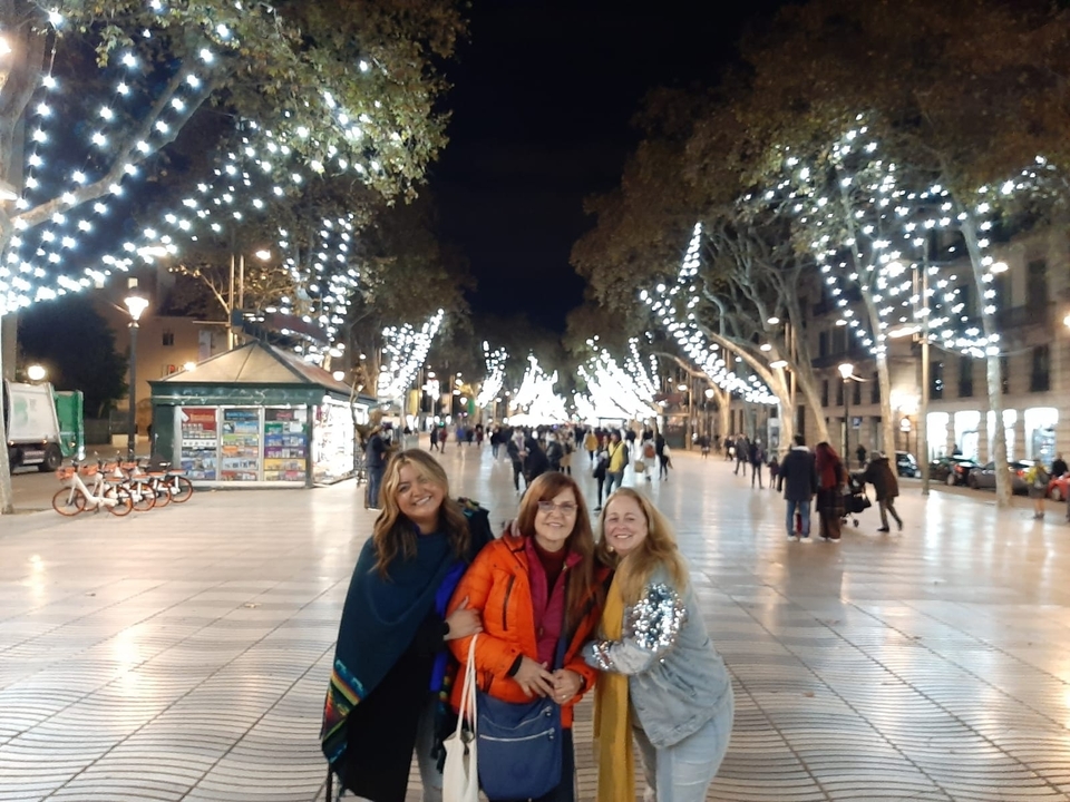 Trois femmes posant sous les lampadaires la nuit.