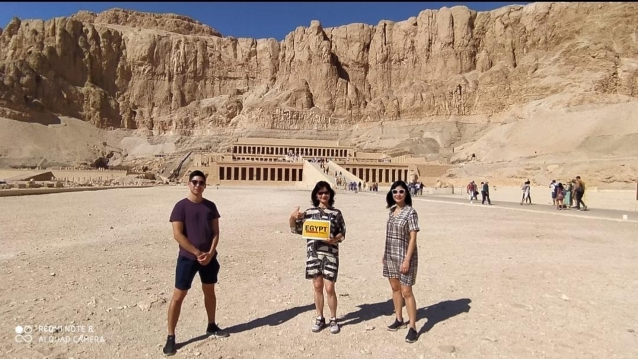 Groupe de touristes posant devant le temple funéraire d'Hatchepsout.