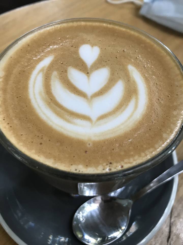 Tasse de latte avec art de mousse sur une soucoupe.