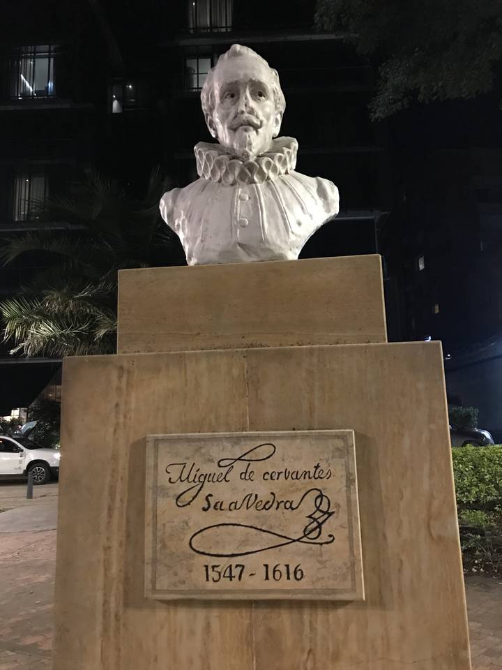 Statue de Miguel de Cervantès sur un piédestal la nuit.