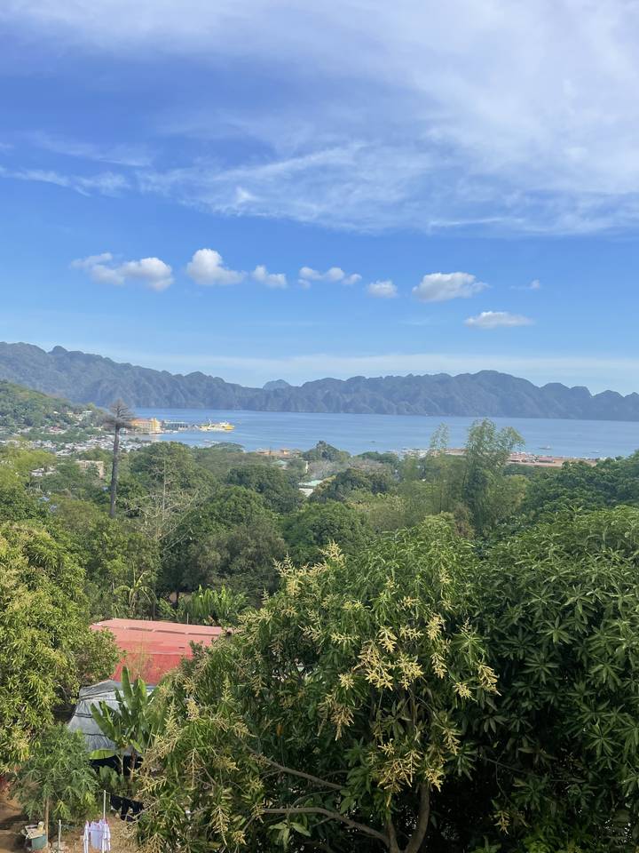 Scenic overview of a coastal landscape with mountainous terrain and blue skies.
